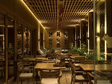 Heatscope Vision 3200W Radiant Heater, matte-black, ceiling-mounted above open-air restaurant tables, delivers silent infrared electric patio warmth.